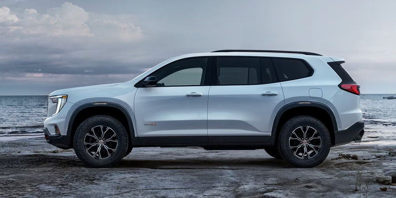 2026 GMC Acadia midsize SUV on highway highlighting modern styling and road presence